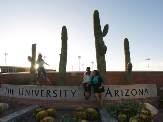 UA students at the stone landmark signage