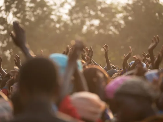 People in crowd with hands raised